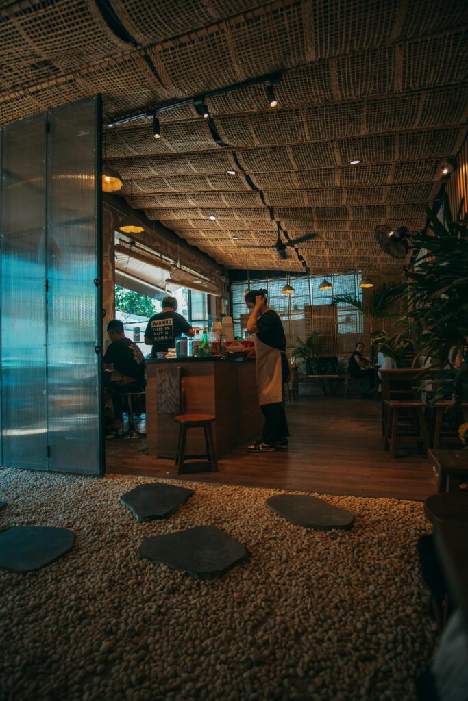 Warm café atmosphere with people enjoying drinks and staff serving customers.